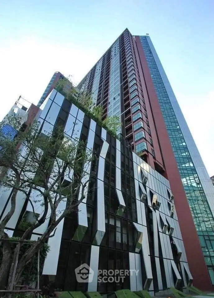 Stunning modern high-rise building with unique architectural design and lush greenery.