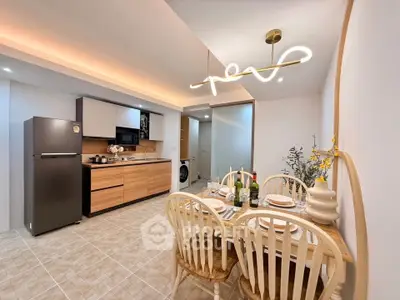 Modern kitchen with dining area, sleek cabinets, and stylish lighting