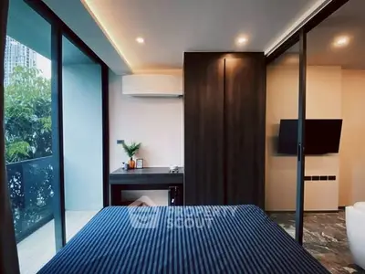 Modern bedroom with balcony access and sleek interior design in urban apartment.