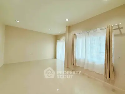 Spacious empty room with large windows and elegant curtains, perfect for customization.