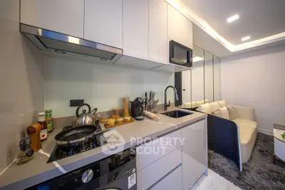 Modern kitchen with sleek design and open layout, featuring stainless steel appliances and cozy living area.