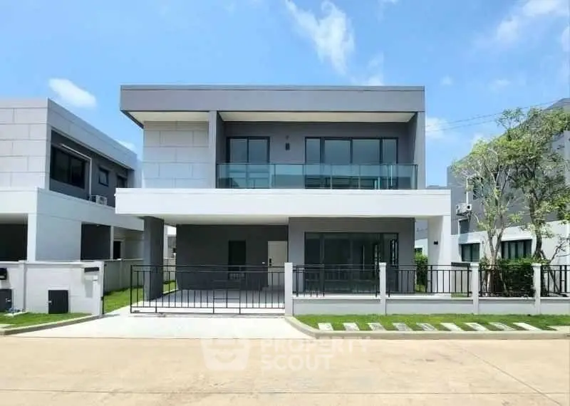 Modern two-story house with sleek design and spacious balcony in a serene neighborhood.