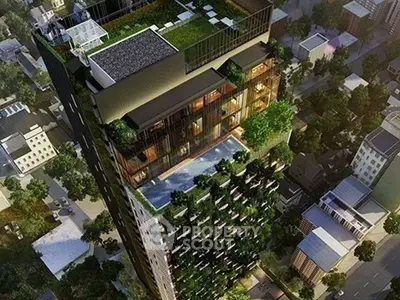 Stunning aerial view of a modern high-rise building with lush greenery and rooftop pool.