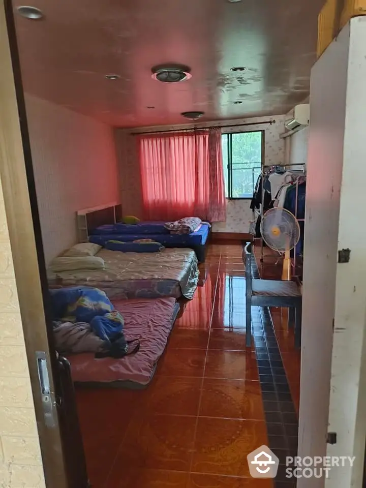 Cozy bedroom with multiple beds and natural light from window