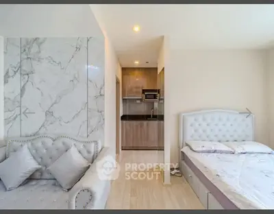 Modern studio apartment with elegant marble accent wall and cozy furnishings