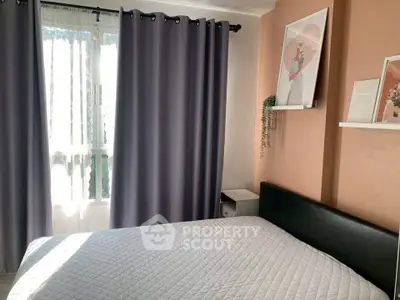 Cozy bedroom with modern decor and ample natural light from large window.