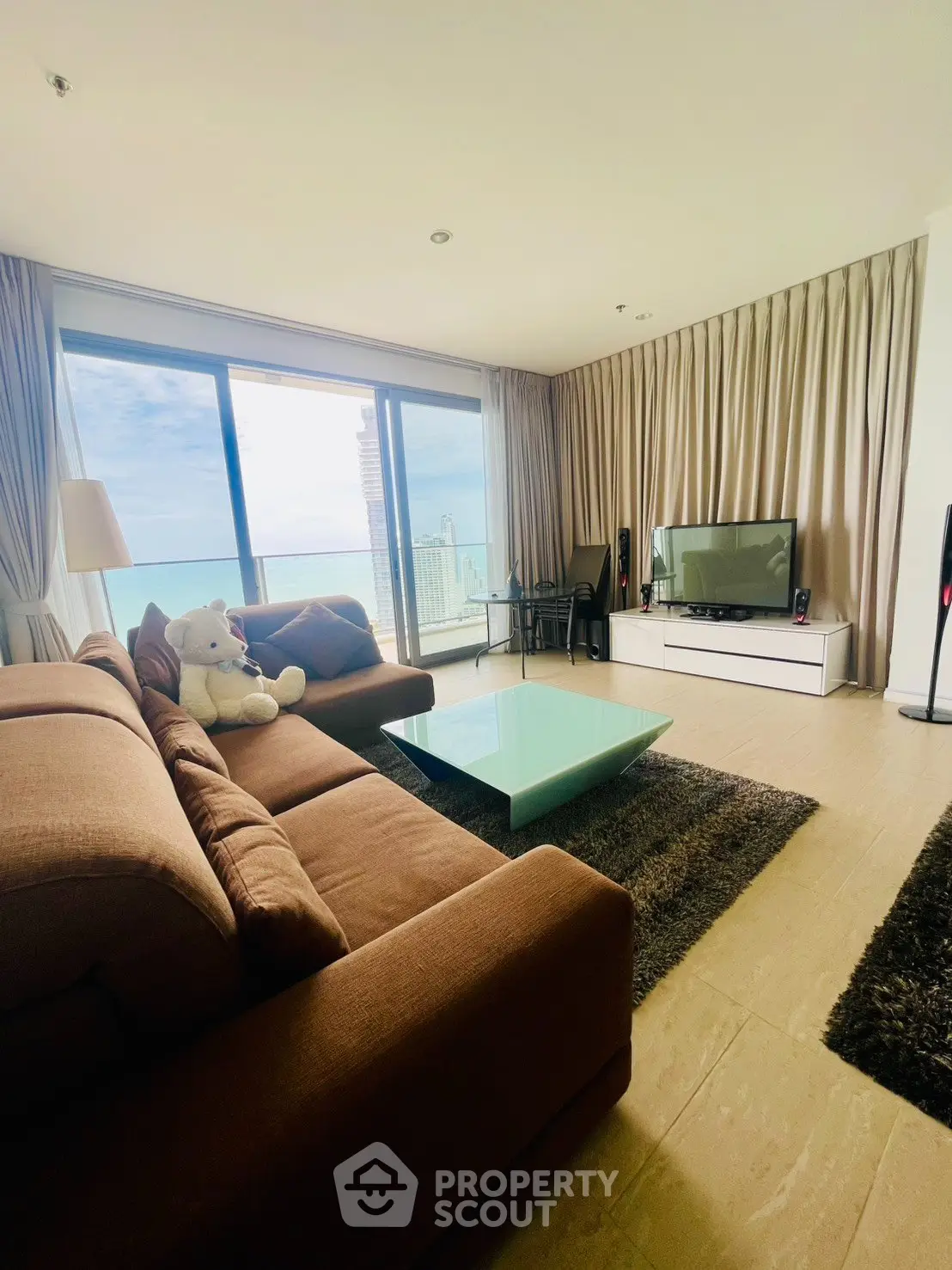 Spacious living room with stunning ocean view, modern furniture, and large windows for natural light.