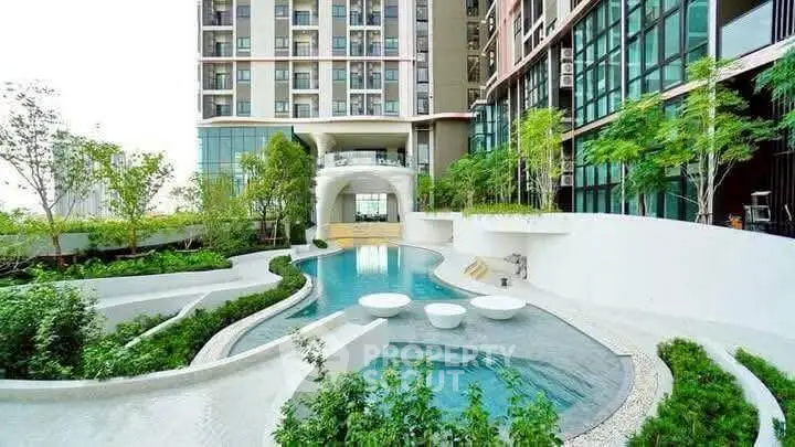 Luxurious modern apartment complex with stunning pool and lush greenery.