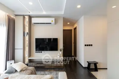 Modern living room with sleek design, wall-mounted TV, and cozy seating area.