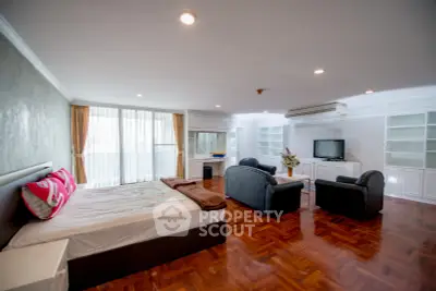Spacious studio apartment with modern furnishings and large windows for natural light.