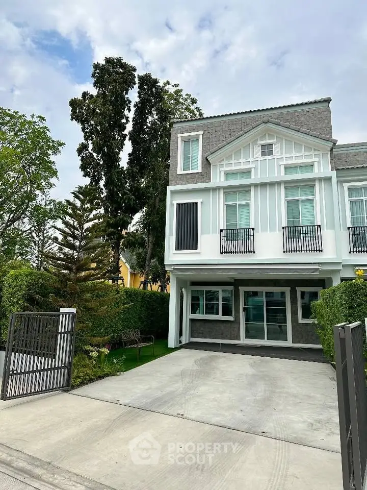 Modern townhouse with spacious driveway and lush greenery, perfect for family living.