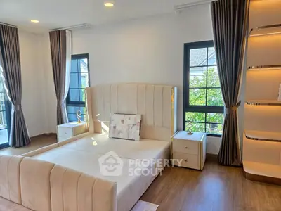 Luxurious bedroom with elegant decor and large windows offering natural light