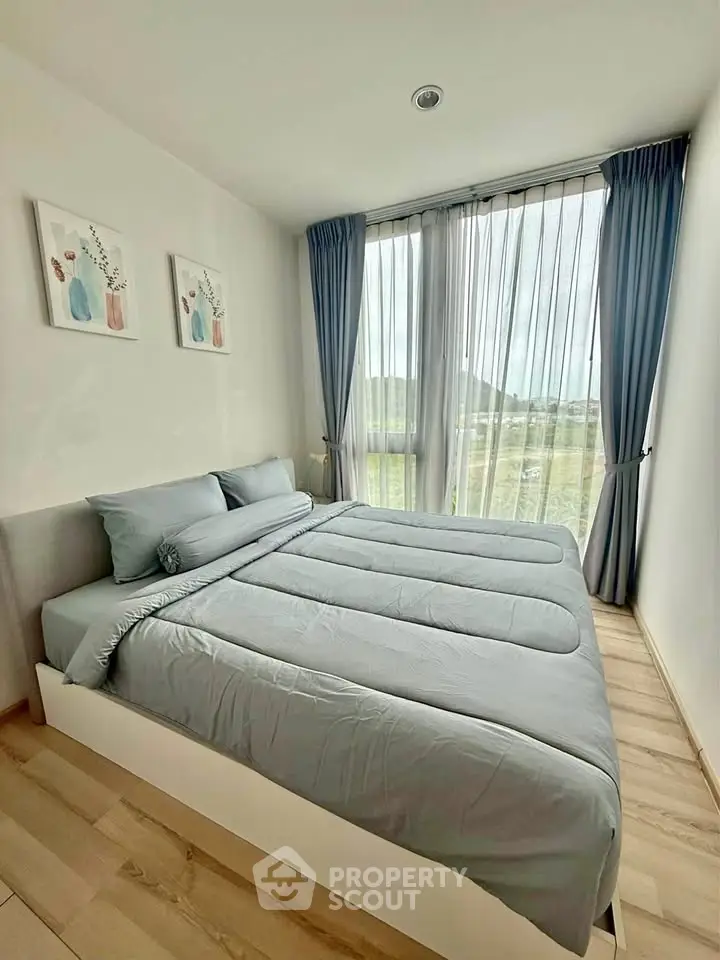 Modern bedroom with large window and scenic view, featuring stylish decor and natural light.