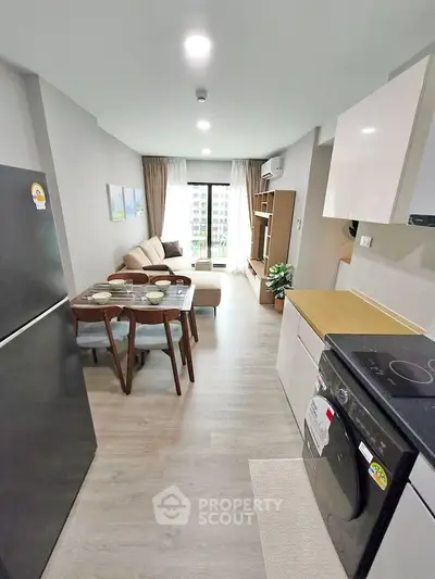 Modern open-plan kitchen and living room with stylish furnishings and natural light.