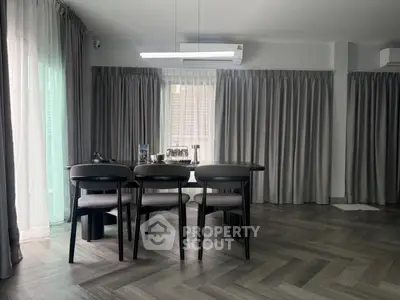 Elegant dining area with modern table and chairs, featuring stylish gray curtains and flooring.