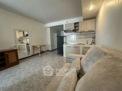 Cozy living room with compact kitchen and comfortable sofa in modern apartment.
