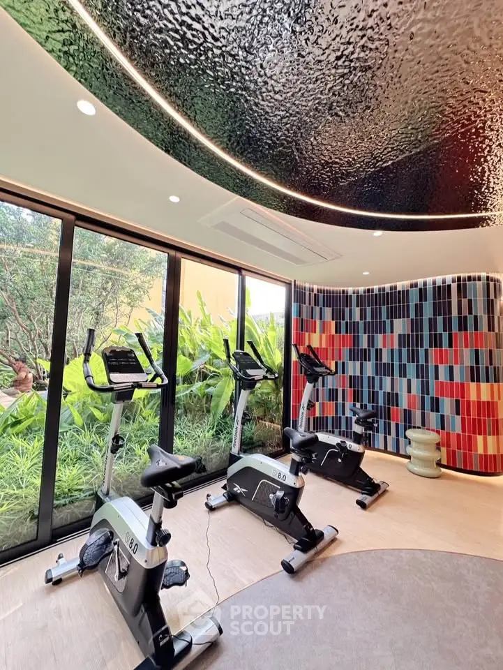 Modern gym with exercise bikes and vibrant decor in a luxury real estate property.