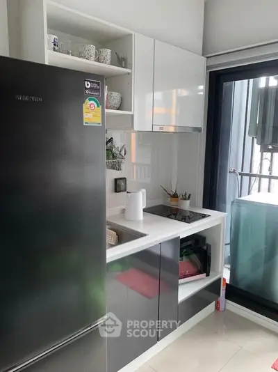 Modern compact kitchen with sleek appliances and balcony view