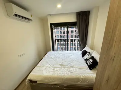 Cozy bedroom with city view, featuring a comfortable bed and modern air conditioning.