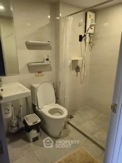 Modern bathroom with shower, toilet, and sink in a sleek, tiled design.