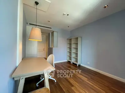 Spacious study room with modern desk and shelving, featuring elegant wooden flooring.