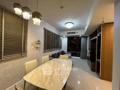 Modern dining and living area with elegant lighting and large windows