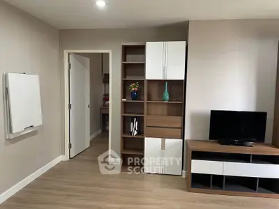 Modern living room with sleek shelving and TV unit, showcasing minimalist design and warm wood tones.