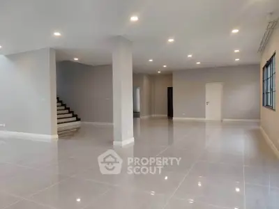 Spacious open-plan living area with modern lighting and sleek tile flooring