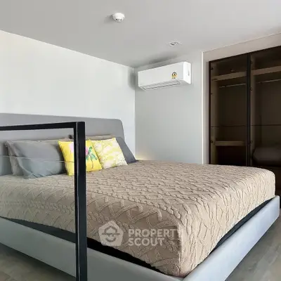 Modern bedroom with stylish decor and built-in closet, featuring a comfortable bed and air conditioning.