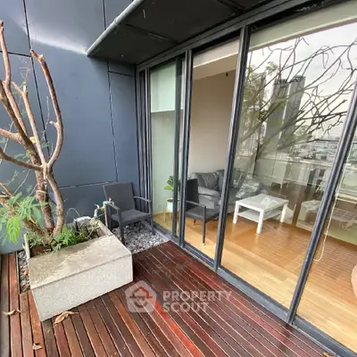 Modern balcony with wooden flooring and glass doors overlooking cityscape