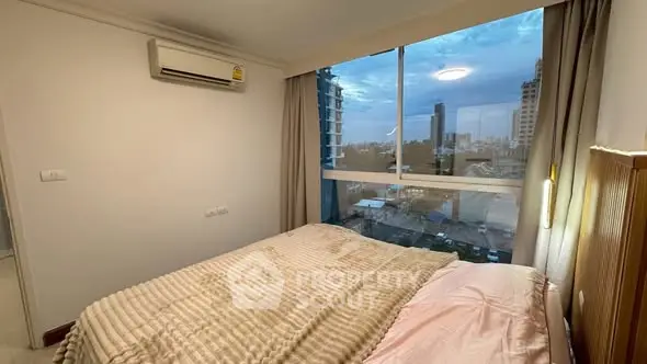 Cozy bedroom with city view and air conditioning in modern apartment.