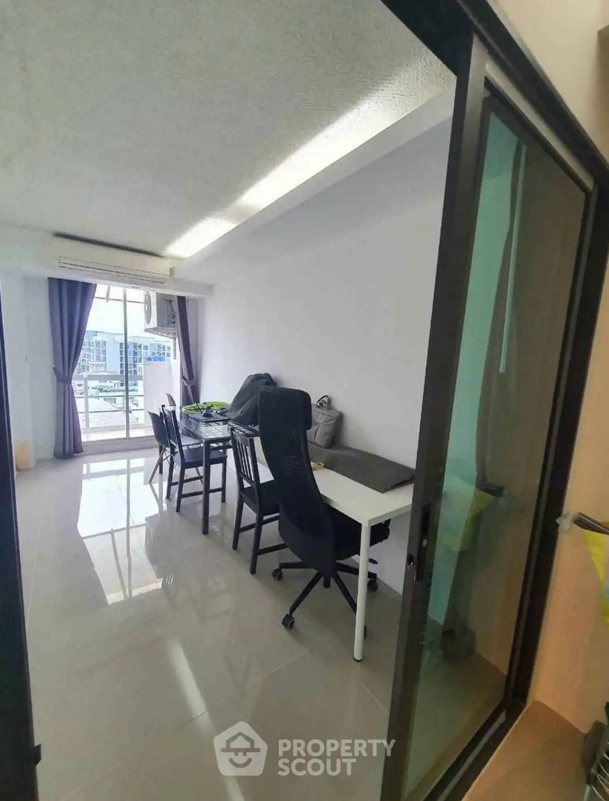 Spacious living room with modern furniture and large windows offering city views.