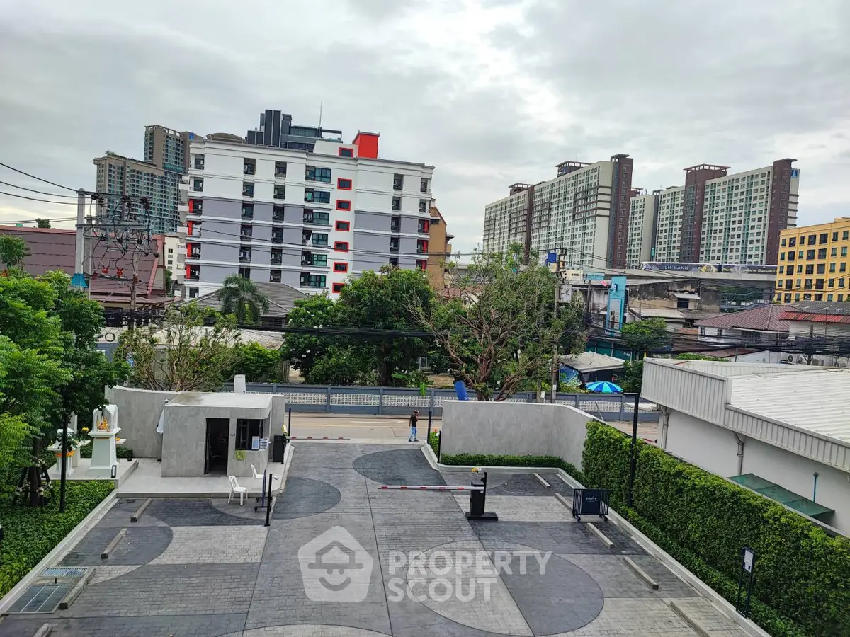 Modern urban apartment complex with lush greenery and cityscape view