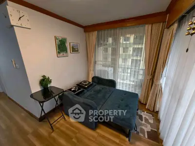 Cozy living room with stylish blue sofa and elegant curtains, perfect for relaxation.