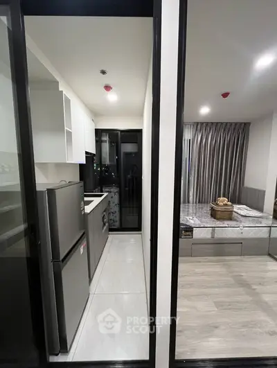 Modern compact kitchen with sleek design and adjacent cozy bedroom