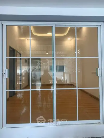 Spacious room with large sliding glass doors and wooden flooring, ideal for natural light and modern living.