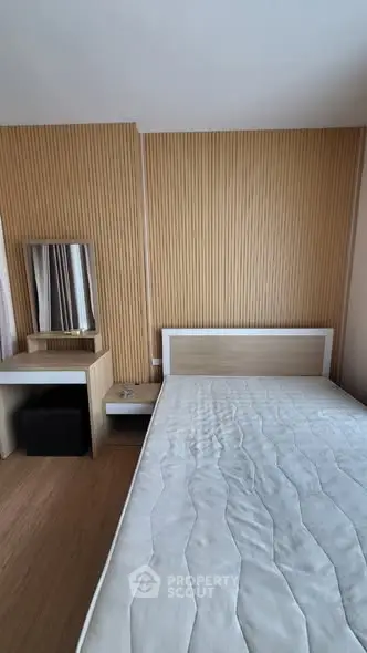 Modern bedroom with wooden accent wall and minimalist furniture design.