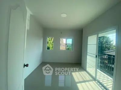 Bright empty room with large windows and balcony access, perfect for customization.