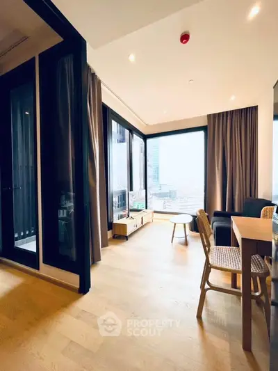 Modern living room with large windows and city view, featuring stylish furniture and wooden flooring.