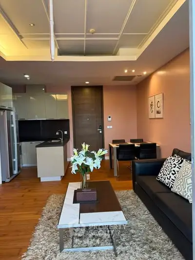 Modern living room with open kitchen, stylish decor, and cozy seating area in a contemporary apartment.