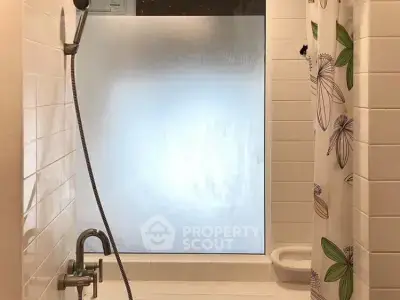 Modern bathroom with frosted glass shower and floral curtain
