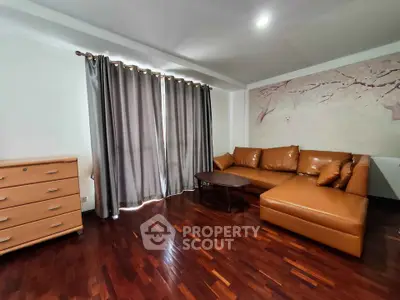 Spacious living room with elegant leather sofa and hardwood floors