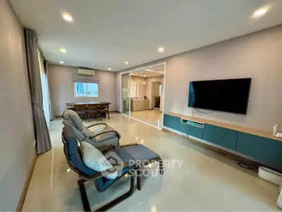 Spacious modern living room with sleek furniture and wall-mounted TV