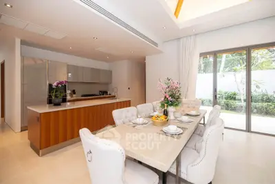 Luxurious open-layout kitchen and dining area with elegant decor and garden view.