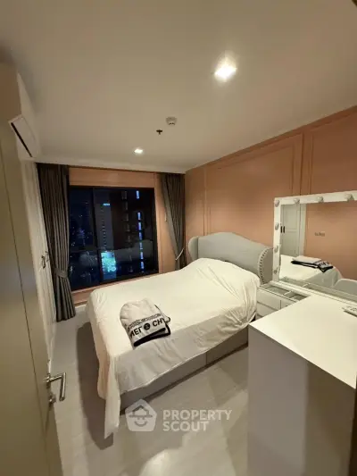 Cozy bedroom with city view, featuring elegant decor and a comfortable bed, perfect for relaxation.