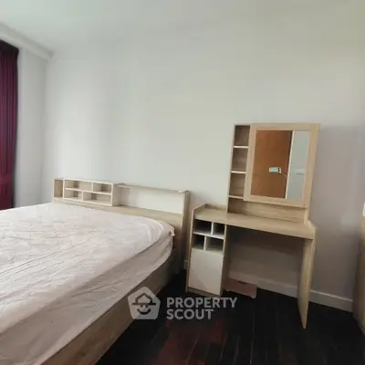 Modern bedroom with sleek wooden furniture and dark flooring