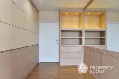 Modern minimalist storage room with built-in wooden cabinets and sleek design.