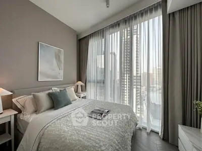 Luxurious bedroom with floor-to-ceiling windows offering stunning city views, elegant decor, and cozy ambiance.