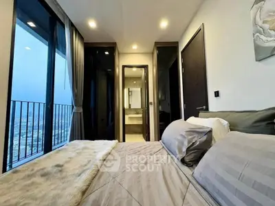 Luxurious bedroom with stunning city view and modern ensuite bathroom in high-rise apartment.
