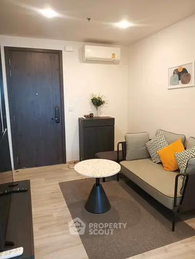 Modern living room with stylish sofa, air conditioning, and elegant decor in a cozy apartment.